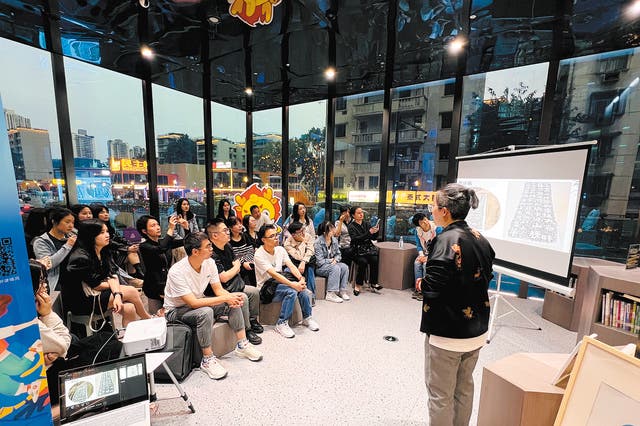 <p>Students at Jiulongpo Youth Night School learn about the craft of making rubbings at the Wanxiang Bookstore in Chongqing’s Jiulongpo district in April</p>